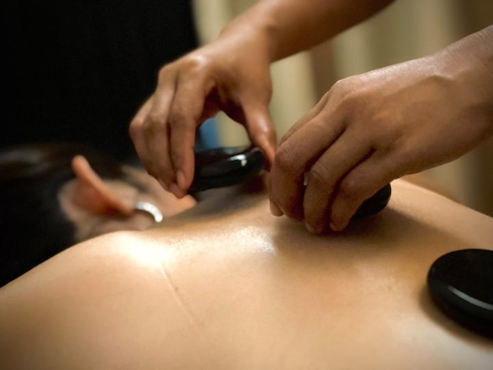 Hot stone massage treatment in progress